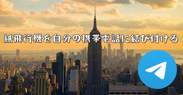 紙飛行機を自分の携帯電話に結び付ける